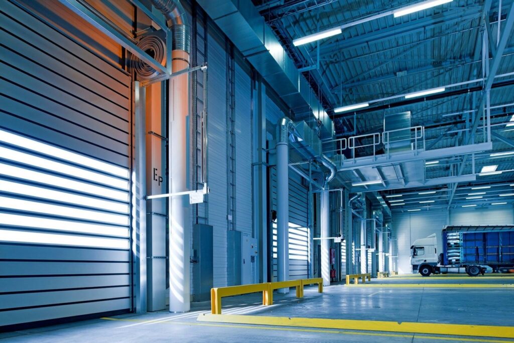 Industrial facility interior with multiple overhead doors as part of a planned commercial overhead door maintenance program in Maine.