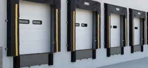 Commercial garage door installation at a loading dock with multiple overhead doors and dock leveler bays at a commercial facility