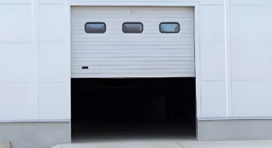Commercial garage door repair signs at an industrial facility overhead door entrance